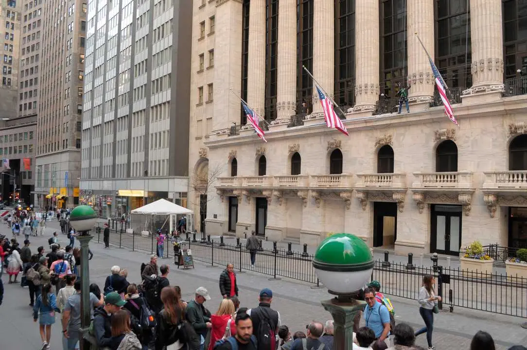 People walk past the New York Stock Exchange in the Financial District in Manhattan, New York City.