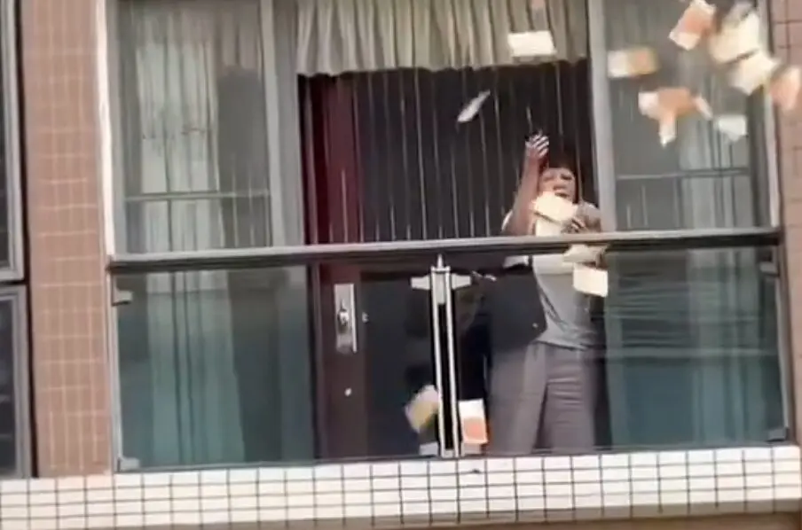 La mujer china tirando el dinero. Foto: Redes sociales.