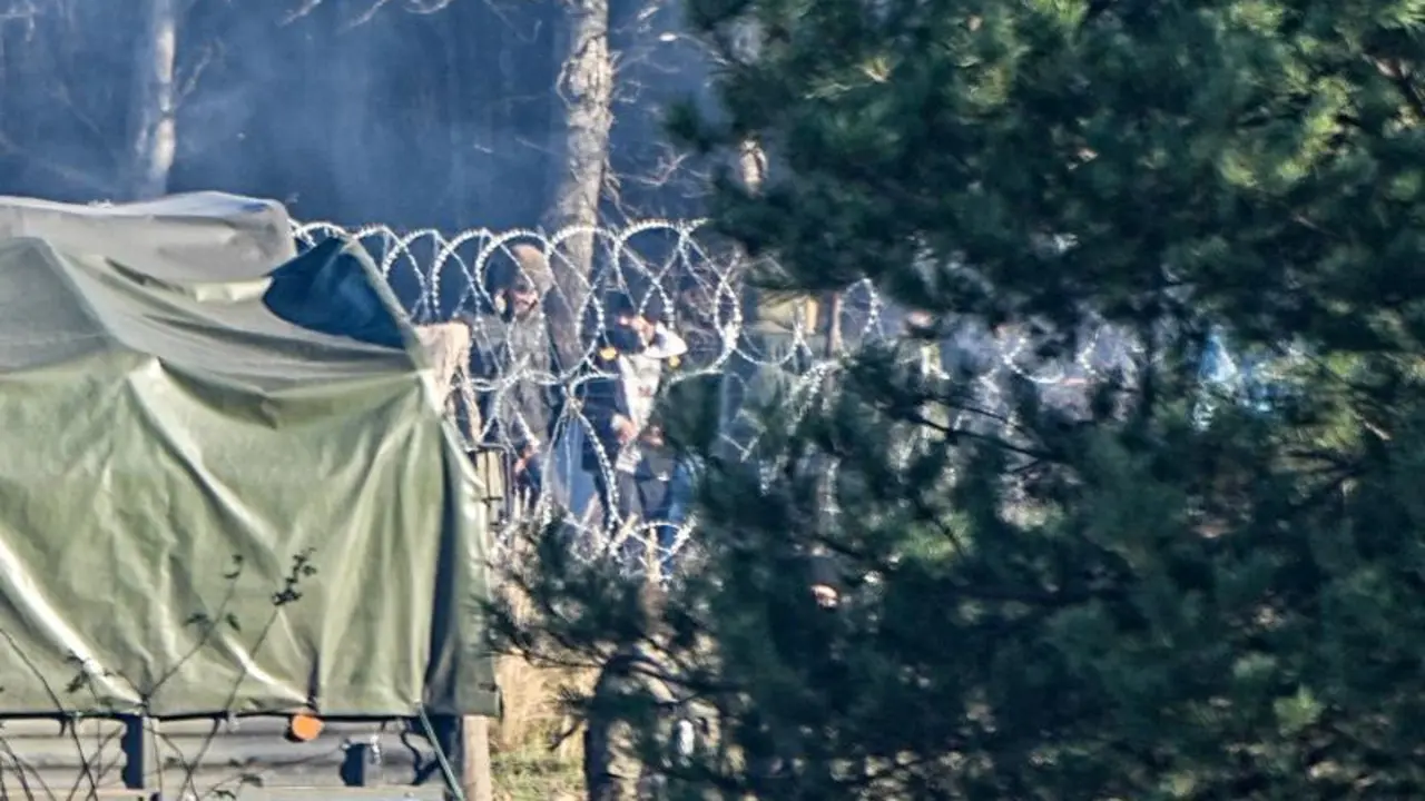 09 November 2021, Poland, Kuznica: Migrants stand behind the barbed wire border between Poland and Belarus near the Kusnica border crossing. The migration crisis at the Poland-Belarus border with refugees trying to enter the European Union via Belarus worsened on Monday, with Belarusian authorities saying that many hundreds of migrants had arrived at the border, and Poland reporting that some had already tried to break through. Photo: Michael Kappeler/dpa
(Foto de ARCHIVO)
09/11/2021 ONLY FOR USE IN SPAIN