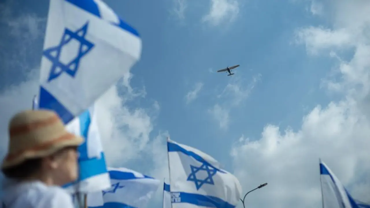 07 July 2024, Israel, Raanana: A plane flies over Israeli protesters as they shout slogans and hold Israeli flags in a rally to mark 9 months since the Hamas attack which took place on 07 October. Photo: ILIA YEFIMOVICH/dpa
07/7/2024 ONLY FOR USE IN SPAIN