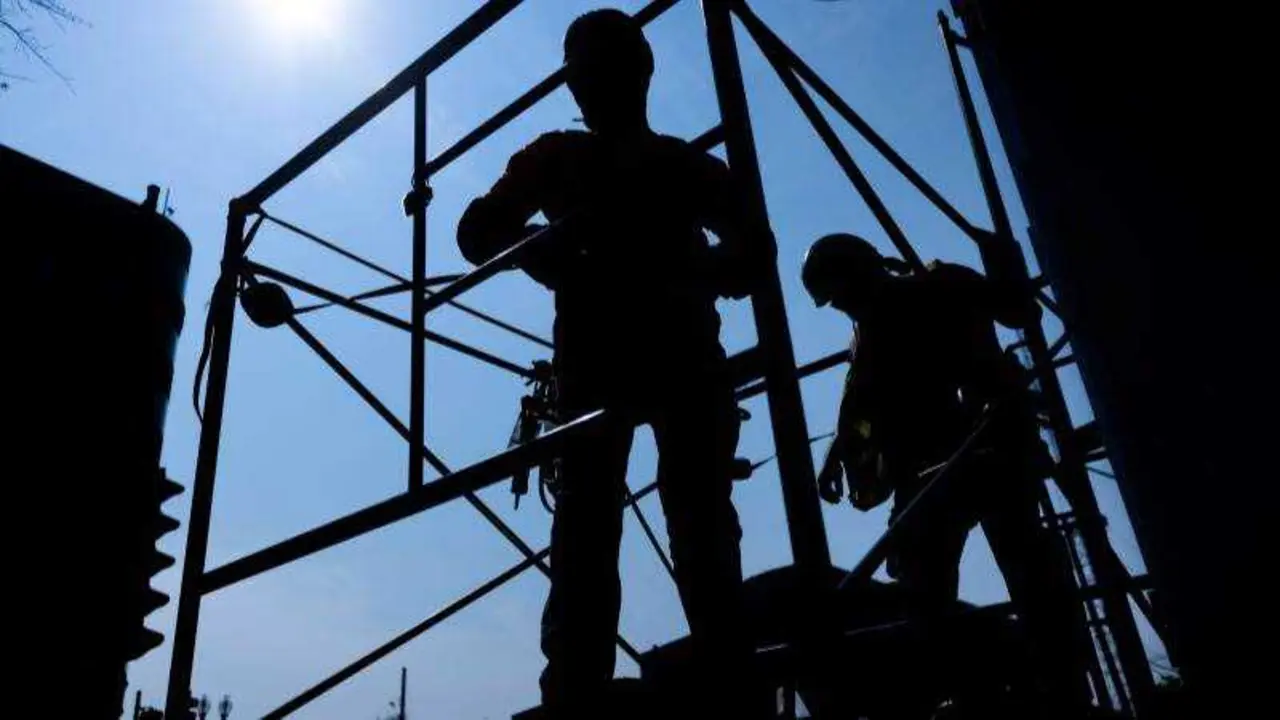 Trabajadores de la construcci&oacute;n sobre un andamio en una obra, EPA/JIM LO SCALZO