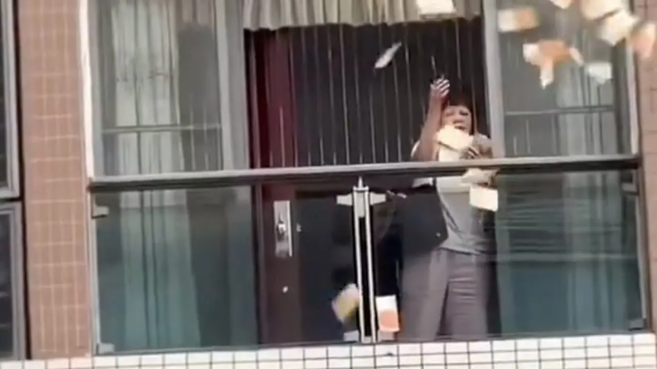 La mujer china tirando el dinero. Foto: Redes sociales.